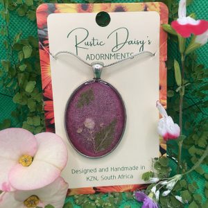Large oval silver coloured pendant with metallic cerise background and Baby Breath white flowers with fern leaves