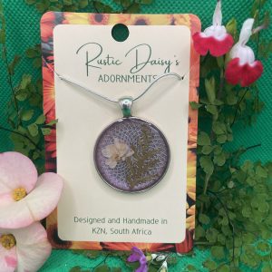 medium-large-round-silver-coloured-pendant-with-lilac-background-and-white-wild-flower-with-fern-leaf