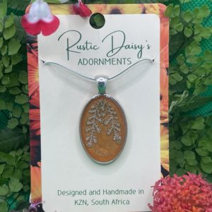 medium-oval-shaped-silver-coloured-pendant-with-metallic-orange-background-and-ferns-leaves
