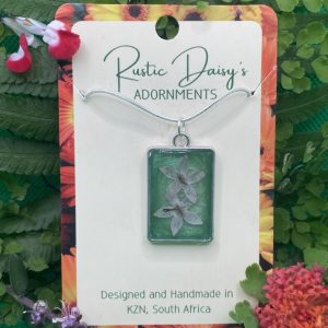 medium-rectangular-silver-coloured-pendant-with-metallic-green-background-and-white-agora-flowers